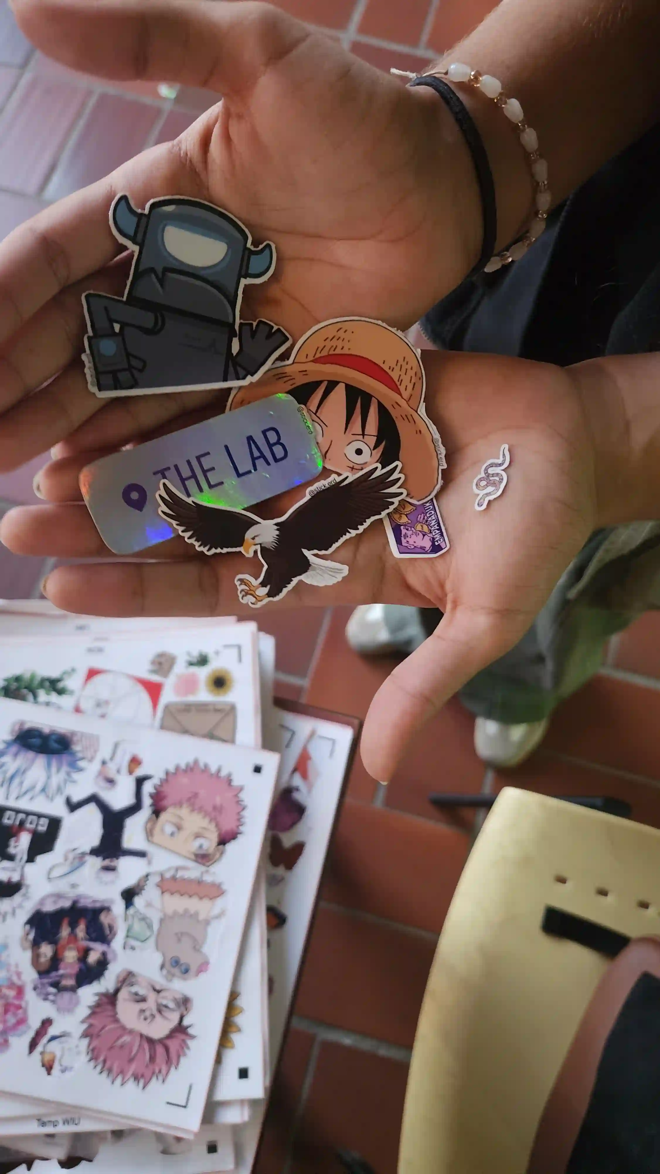 Cliente buscando su diseño ideal en una mesa llena de calcomanías Stickerd