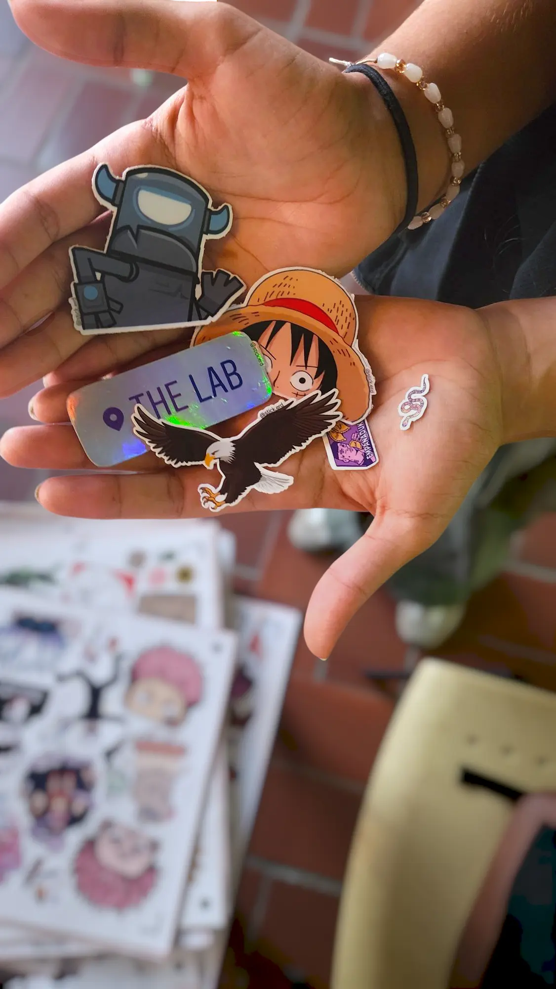 Manos de un cliente sosteniendo un sticker con un diseño único y creativo